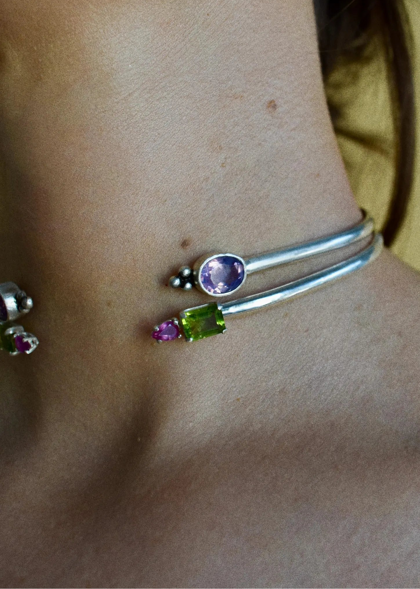 Silver choker necklaces with peridot, amethyst and pink sapphire. Close up on neck