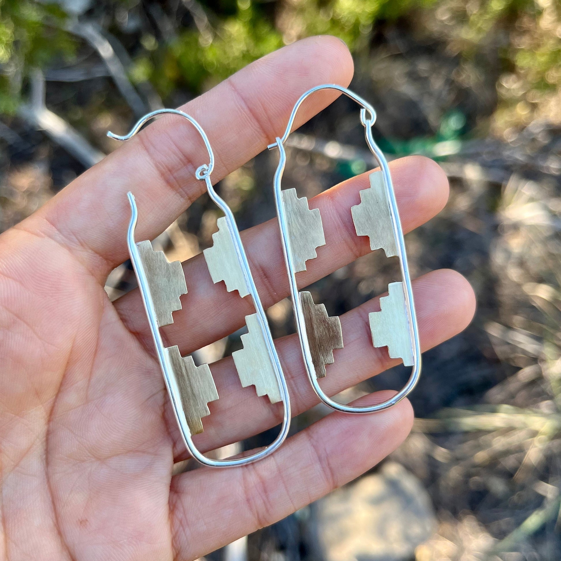 brass and sterling silver hoop earrings with a southwestern pattern